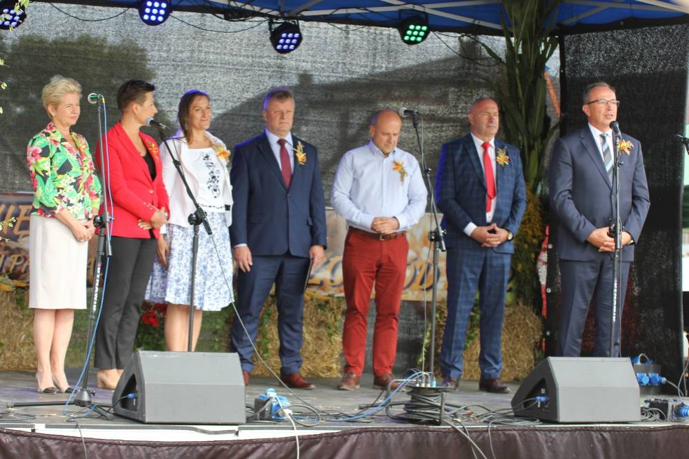 Zdjęcie: Na zdjęciu znajduje się scena, z której przemawia burmistrz Łaz Maciej Kaczyński i zaproszeni na dożynki goście.
